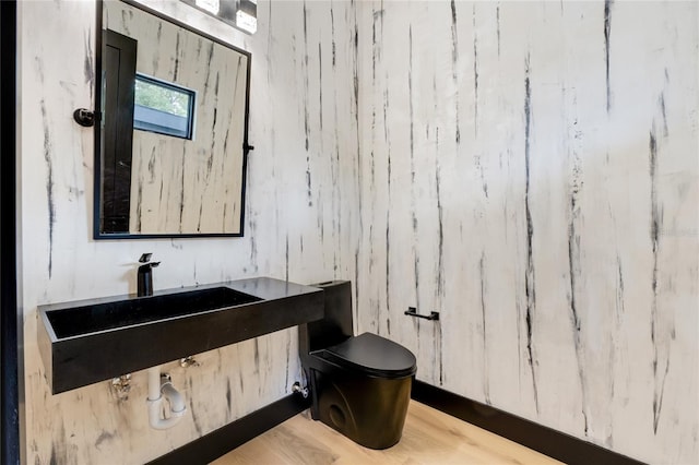 bathroom with toilet and wood finished floors