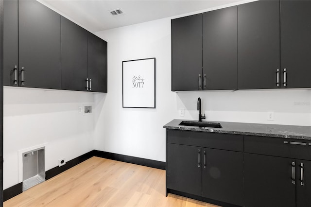 laundry room with cabinet space, light wood finished floors, visible vents, hookup for a washing machine, and a sink