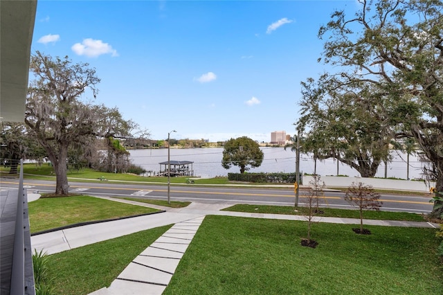 view of community featuring shuffleboard, a lawn, and a water view