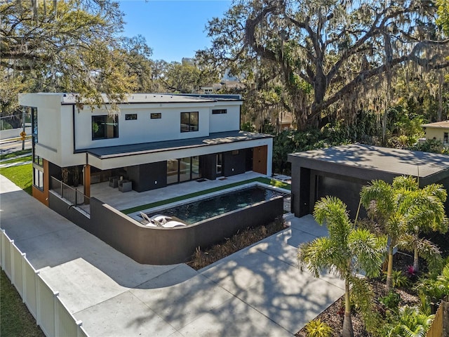 back of property featuring fence private yard, a jacuzzi, a patio area, and stucco siding