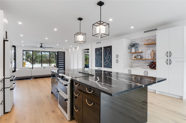 kitchen featuring range with two ovens, tasteful backsplash, freestanding refrigerator, white cabinets, and modern cabinets