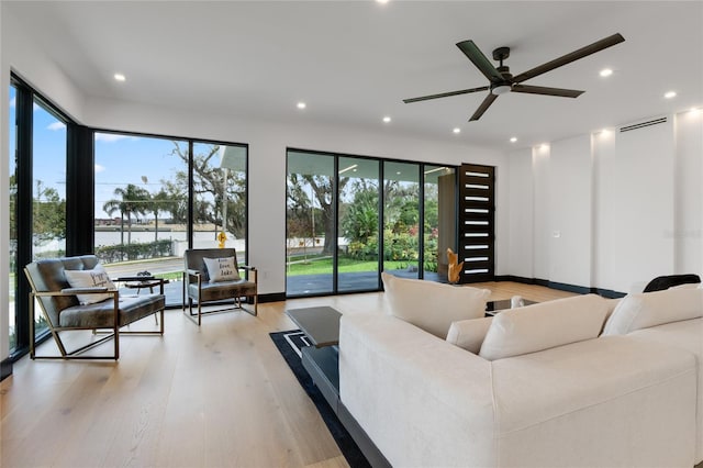 living room with light wood finished floors, a wealth of natural light, and recessed lighting