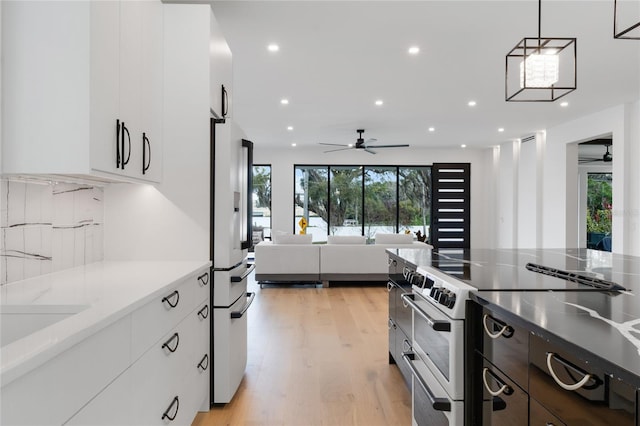 kitchen with modern cabinets, freestanding refrigerator, white cabinetry, and stainless steel range with electric cooktop