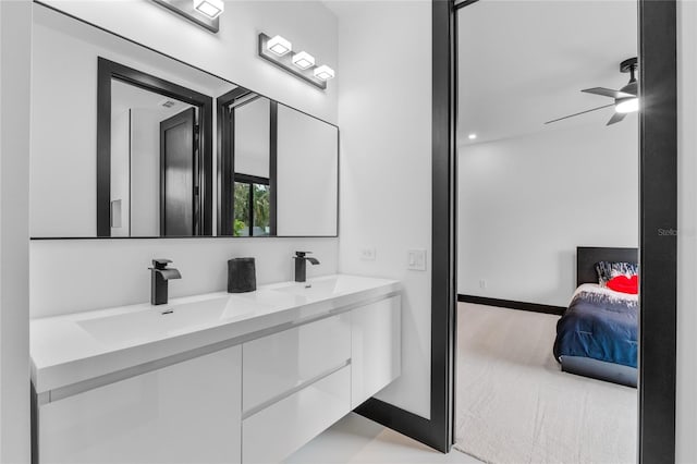 bathroom with a sink, baseboards, and double vanity