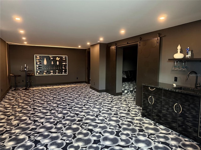 hallway featuring recessed lighting, a sink, and a barn door