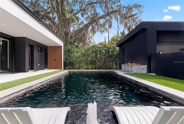 pool with a patio area and fence