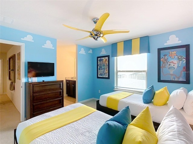 bedroom with light carpet, visible vents, a ceiling fan, and ensuite bathroom