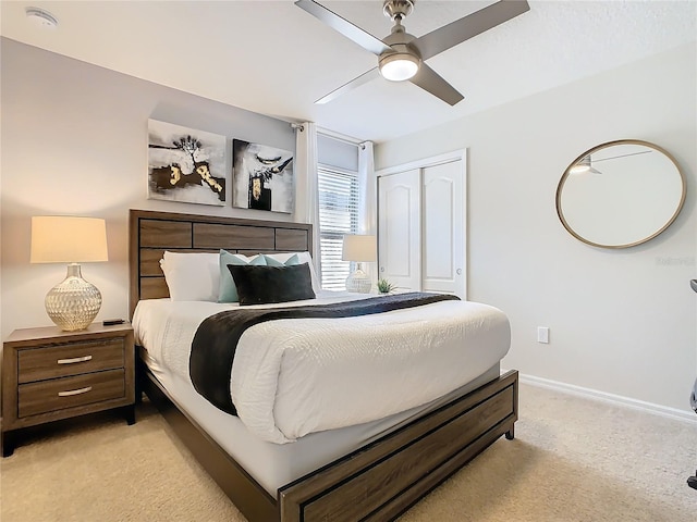 bedroom featuring a closet, light carpet, ceiling fan, and baseboards