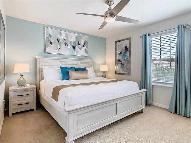 bedroom featuring ceiling fan, baseboards, and light colored carpet