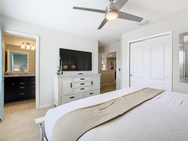 bedroom with visible vents, light colored carpet, ensuite bath, ceiling fan, and a closet