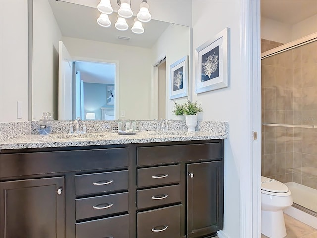 full bath with toilet, a stall shower, double vanity, and a sink