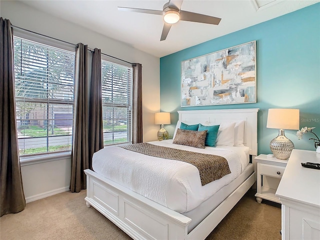 bedroom featuring ceiling fan, carpet floors, multiple windows, and baseboards