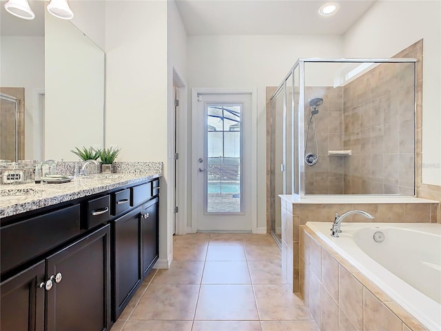 bathroom with a bath, a stall shower, vanity, and tile patterned floors