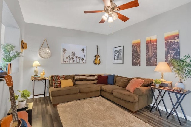 living area with baseboards, a ceiling fan, and dark wood-style flooring