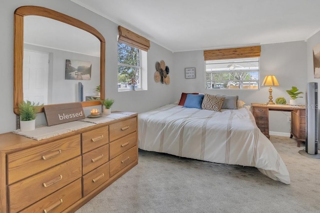 bedroom with multiple windows, crown molding, and light colored carpet