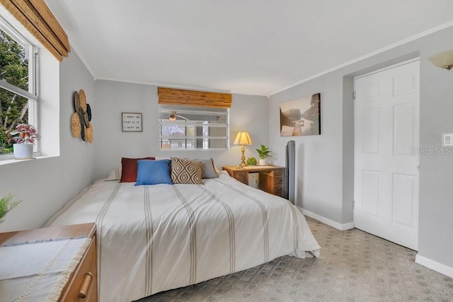 bedroom with baseboards, crown molding, and light colored carpet