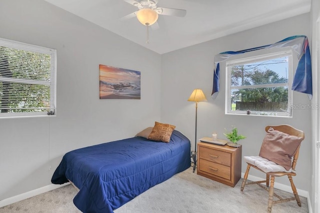 bedroom featuring baseboards, multiple windows, a ceiling fan, and light colored carpet