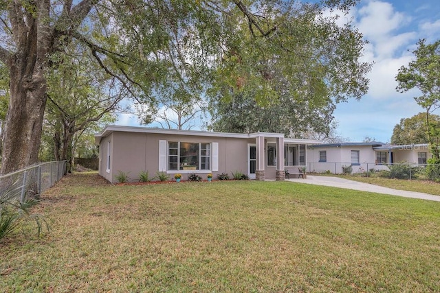 ranch-style house featuring fence, a front lawn, and stucco siding