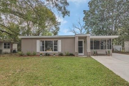 view of front of home featuring concrete driveway and a front lawn