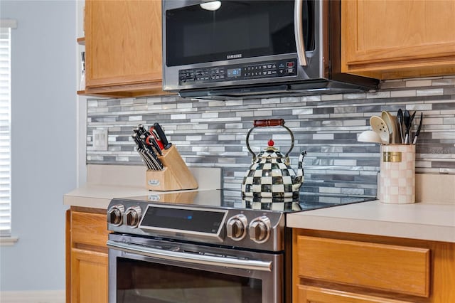 kitchen with light countertops, appliances with stainless steel finishes, and decorative backsplash