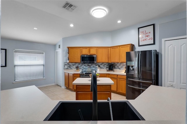 kitchen featuring visible vents, light countertops, fridge with ice dispenser, tasteful backsplash, and stainless steel microwave