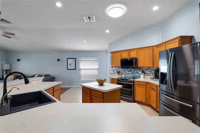 kitchen with range with two ovens, tasteful backsplash, light countertops, fridge with ice dispenser, and a sink