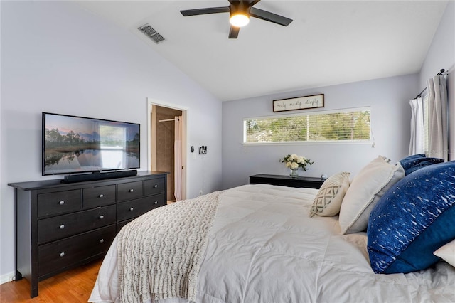 bedroom featuring ceiling fan, light wood-style flooring, visible vents, and vaulted ceiling