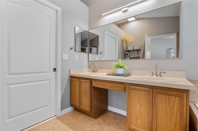 full bath featuring double vanity, tile patterned flooring, a sink, and baseboards