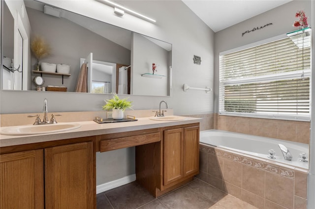 full bath with double vanity, a garden tub, a sink, and tile patterned floors