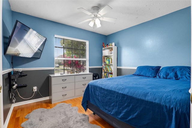 bedroom featuring light wood finished floors, ceiling fan, and baseboards