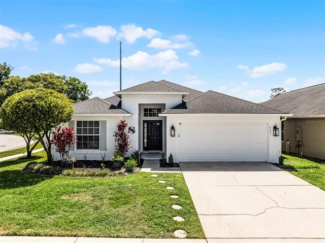 239 Bronze Leaf Ct, Apopka, FL 32703 - view of front of home featuring a garage, stucco siding, a front yard, concrete driveway, and roof with shingles