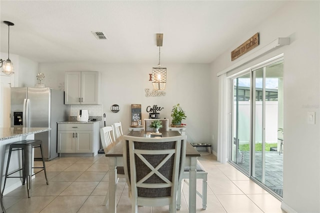 dining area with light tile patterned floors and visible vents