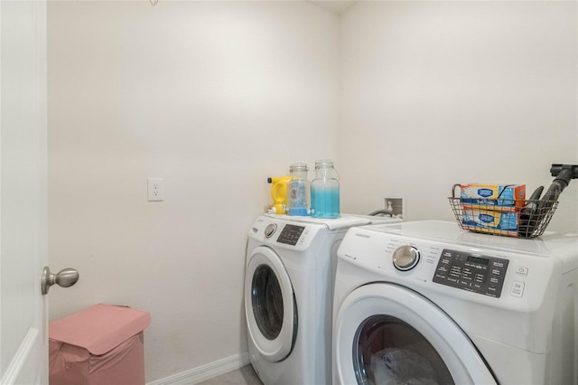 washroom with baseboards, laundry area, and washer and dryer