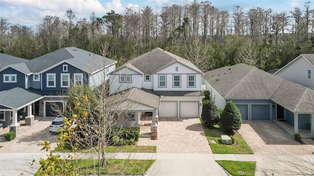 view of front of house featuring a garage, decorative driveway, and roof with shingles