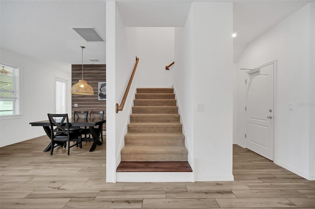 staircase featuring baseboards, visible vents, and wood finished floors