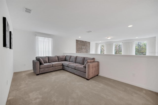 living room with light carpet, baseboards, and visible vents