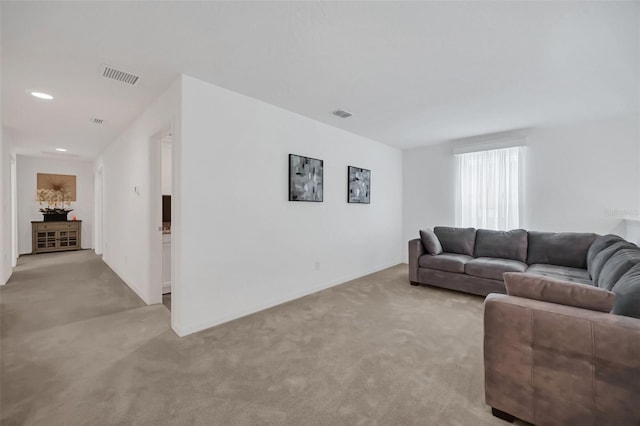 living area with light carpet, visible vents, and recessed lighting