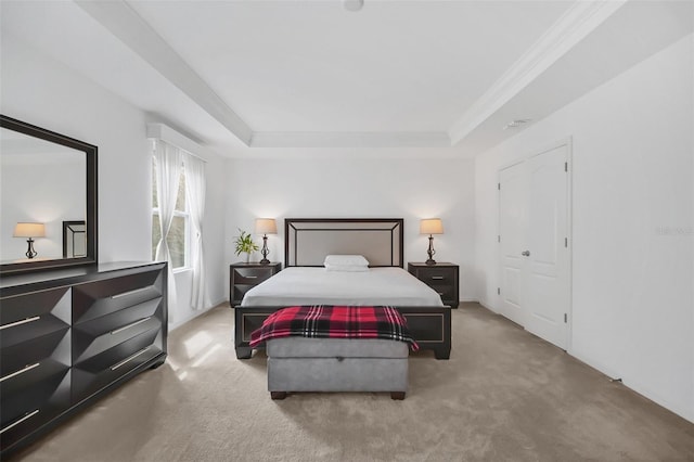 carpeted bedroom with visible vents, a tray ceiling, and crown molding