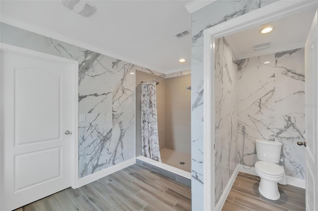 full bathroom with a marble finish shower, visible vents, toilet, wood finish floors, and stone wall