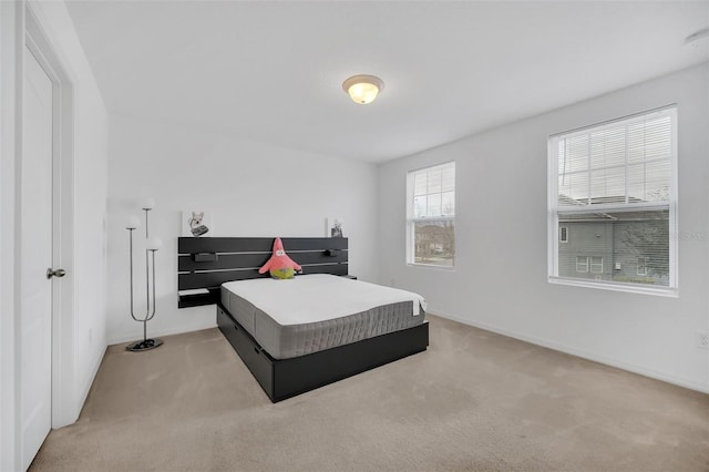 bedroom featuring baseboards and light colored carpet