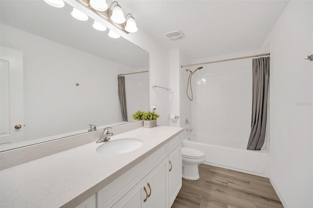 bathroom with visible vents, toilet, wood finished floors, shower / bath combination with curtain, and vanity