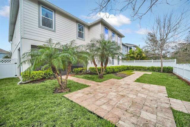 rear view of property with fence private yard, a patio area, and a yard