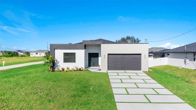 view of front of house with a garage, fence, concrete driveway, stucco siding, and a front lawn