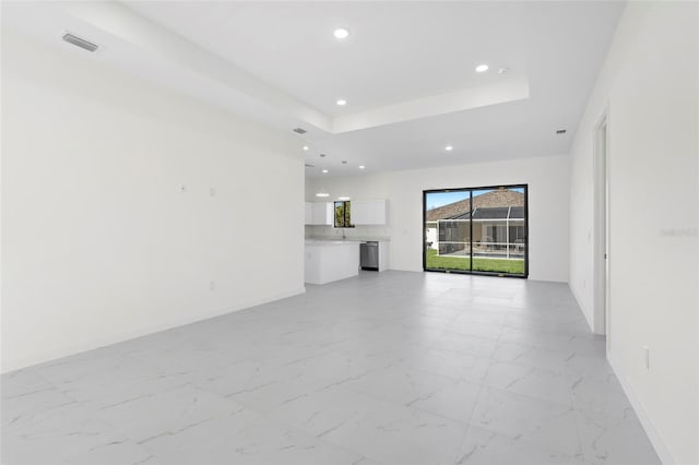 unfurnished living room with marble finish floor, visible vents, a tray ceiling, and recessed lighting