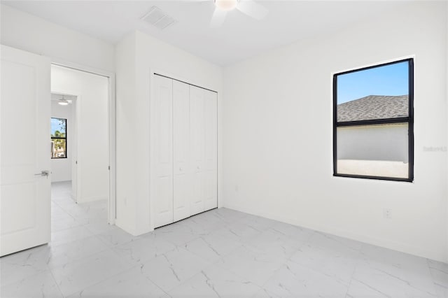 unfurnished bedroom with ceiling fan, visible vents, baseboards, marble finish floor, and a closet