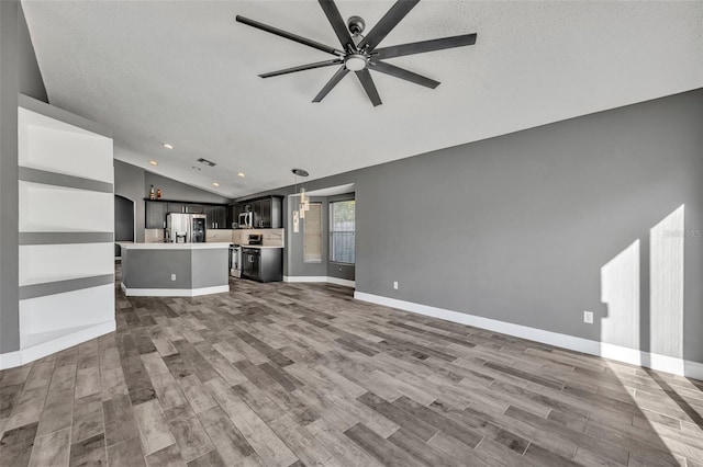 unfurnished living room featuring ceiling fan, baseboards, vaulted ceiling, and wood finished floors