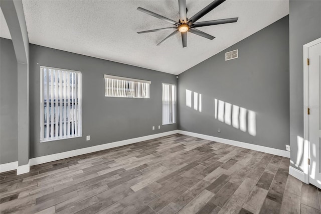 unfurnished room featuring a ceiling fan, visible vents, a textured ceiling, and wood finished floors