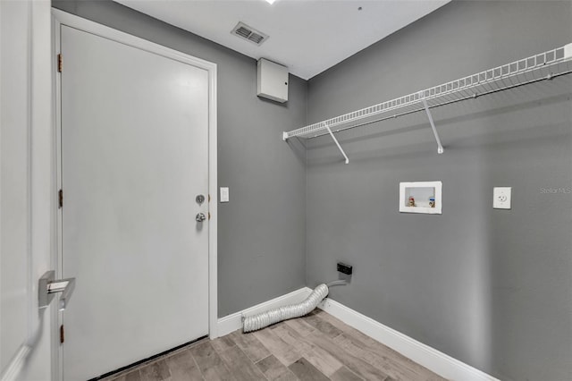 laundry area featuring laundry area, baseboards, visible vents, hookup for an electric dryer, and light wood-type flooring