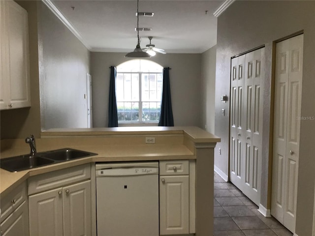 kitchen featuring white dishwasher, a peninsula, a sink, white cabinets, and crown molding