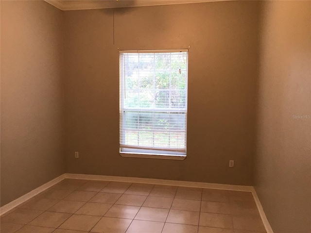 spare room with light tile patterned floors and baseboards